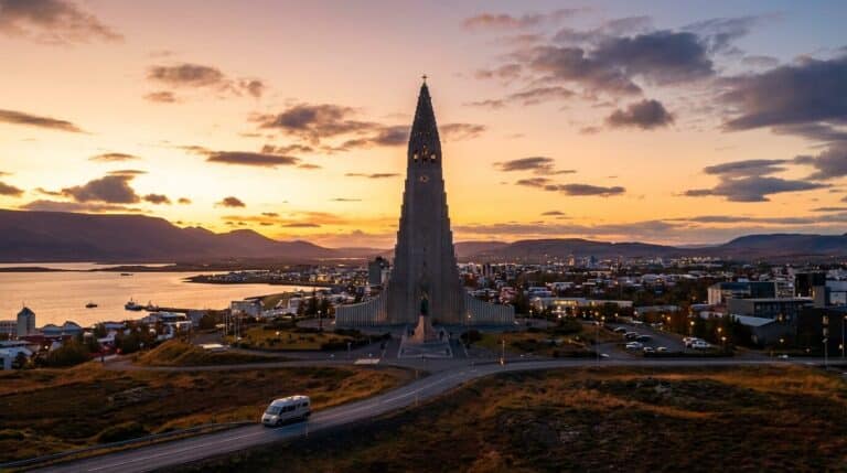 The Hallgrímskirkja church stands over the city of Reykjavík, Iceland, during a vibrant sunset.