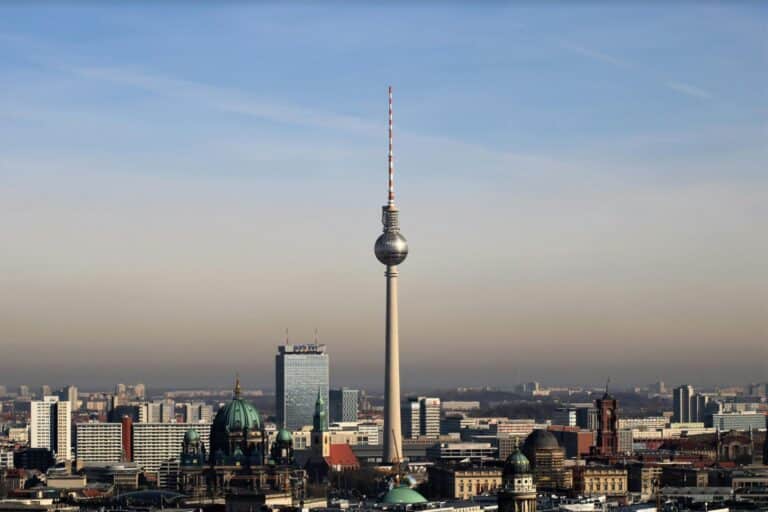An aerial view of the Berlin skyline, featuring the iconic Fernsehturm TV Tower and the Berlin Cathedral.