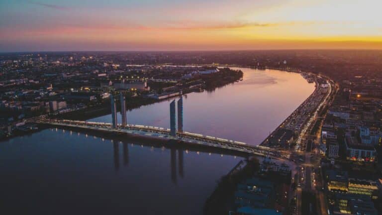 An aerial view of the Pont Jacques Chaban-Delmas crossing the Garonne river in Bordeaux, France at sunset.