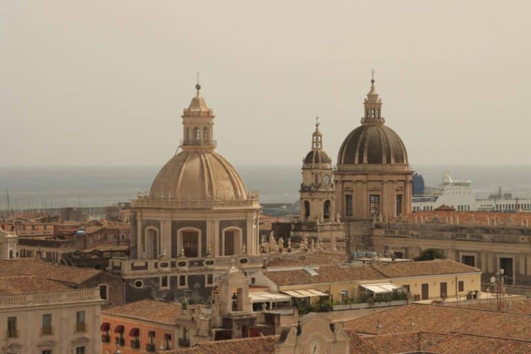 An elevated view of Catania's historic center featuring the domes of the Cathedral and the Badia di Sant'Agata.