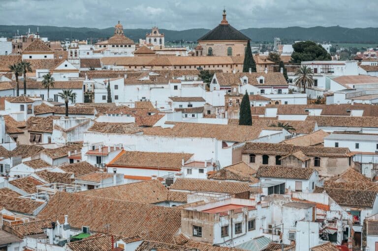An elevated view over the dense terracotta rooftops and whitewashed buildings of the historic city of Córdoba, Spain.