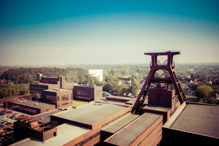 A high-angle view of the red brick buildings and winding tower of the Zollverein Coal Mine Industrial Complex in Essen.