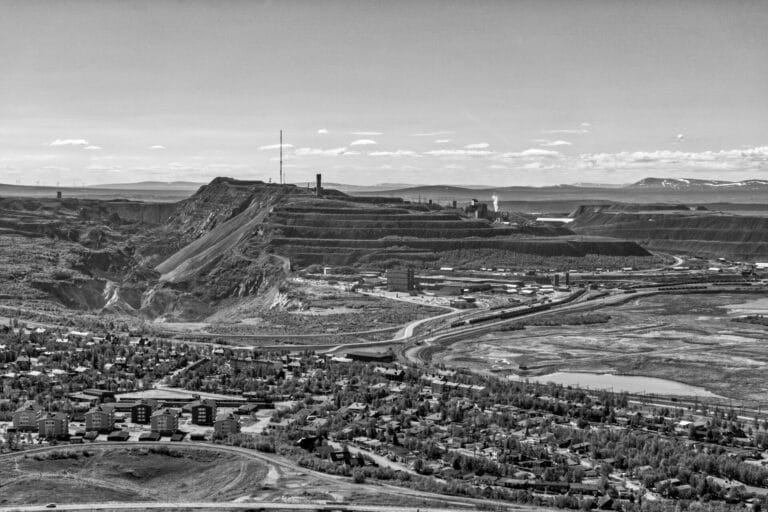 A black and white panoramic view of Kiruna, Sweden, showing the town and the adjacent terraced iron ore mine.