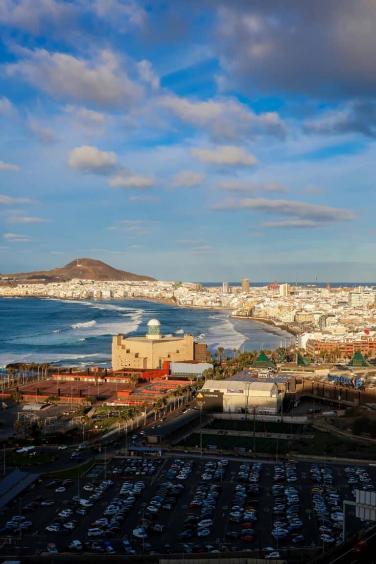 An elevated daytime view of Las Palmas de Gran Canaria, with Las Canteras beach and the Auditorio Alfredo Kraus.