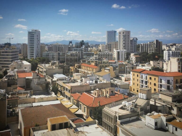 Elevated view of the Nicosia cityscape in Cyprus, showing a mix of old town rooftops and modern towers.