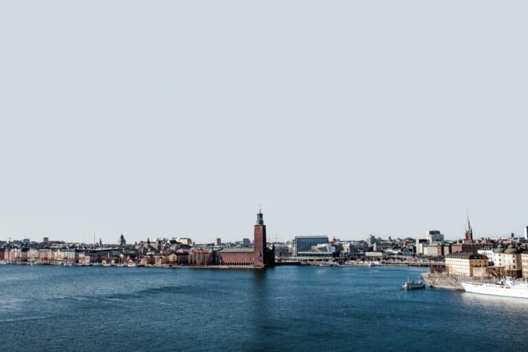 The Stockholm city skyline seen from across the water, with the red-brick City Hall in the center.