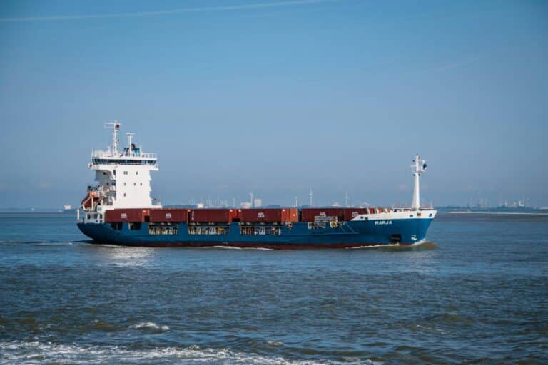The blue and white container ship Marja sailing on the water near the port of Terneuzen.