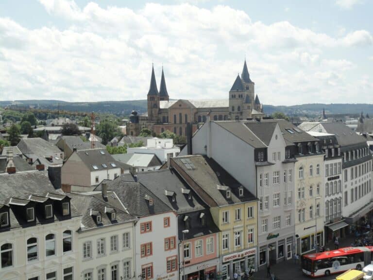 An elevated view over the rooftops of Trier, Germany, with the historic Trier Cathedral in the background.