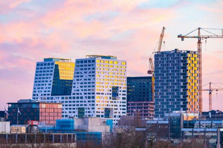 The modern skyline of Utrecht at sunset, with the distinctive Stadskantoor city office buildings and construction cranes.