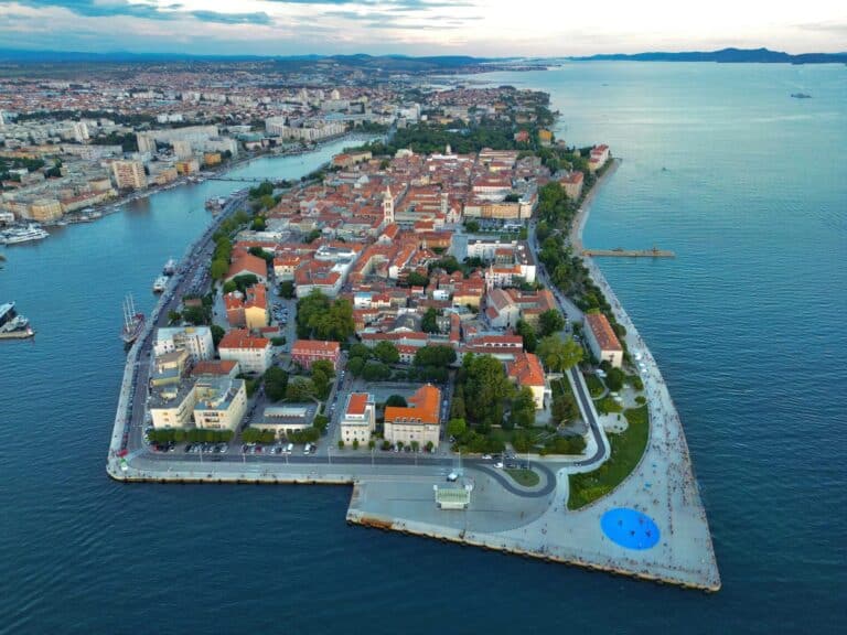 An evening aerial view of the historic Zadar peninsula in Croatia, showing the old town and the Adriatic Sea.