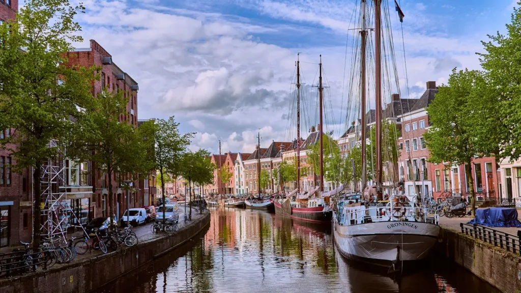 City Game Groningen view of the canal with boat and the street with old buildings, made during golden hour.