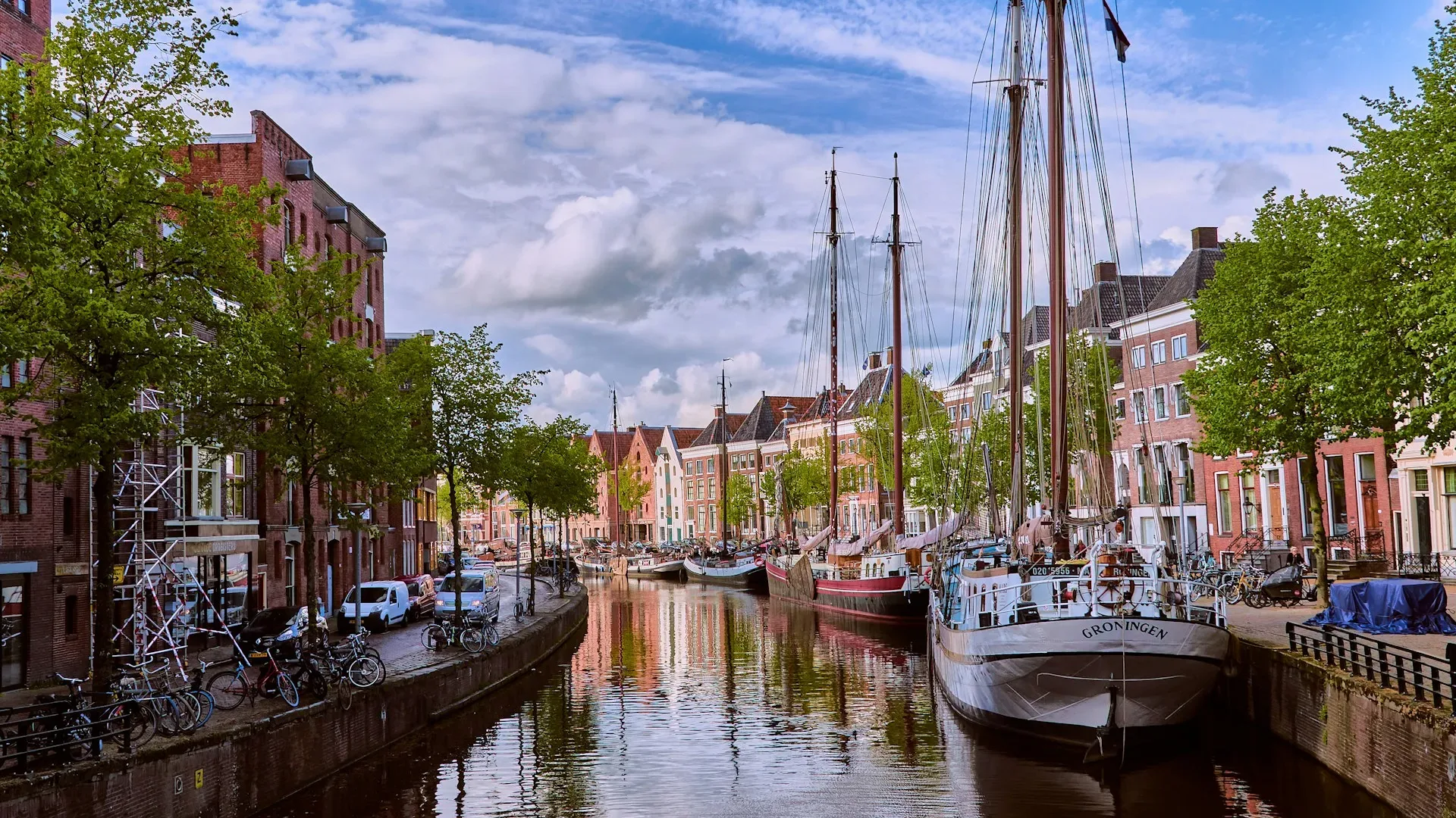 City Game Groningen view of the canal with boat and the street with old buildings, made during golden hour.
