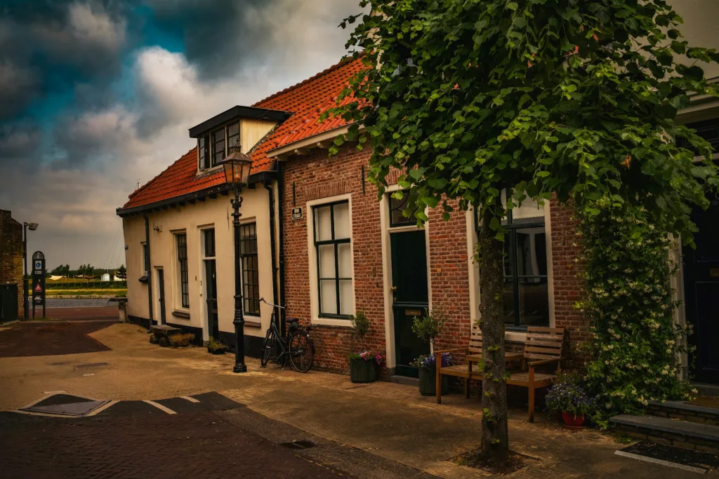 City Game Harderwijk a brick building with a red roof and a tree in front of it