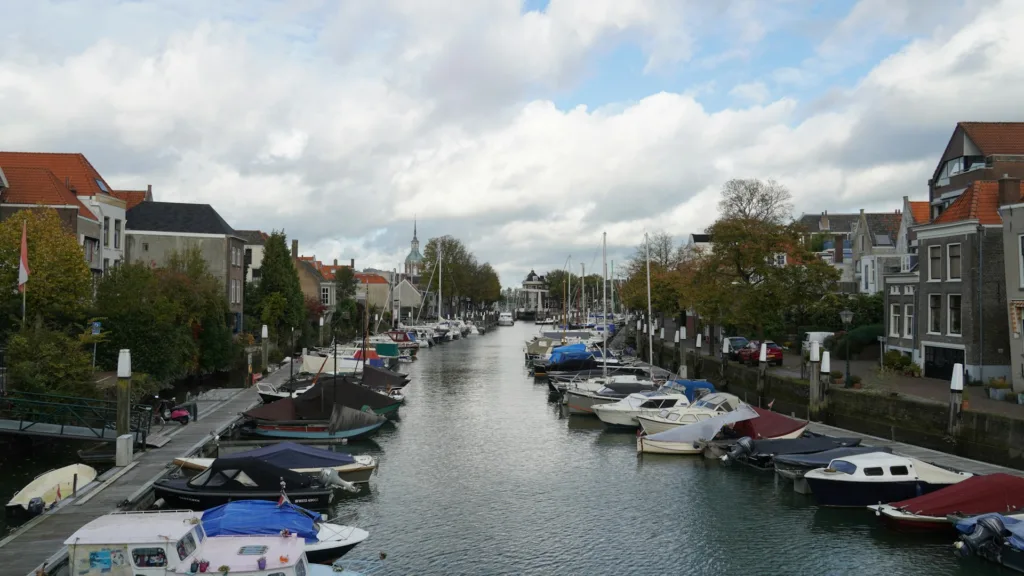 City Game Dordrecht charming canals, lined with historic buildings and colorful boats, showcasing the city's serene and picturesque character.