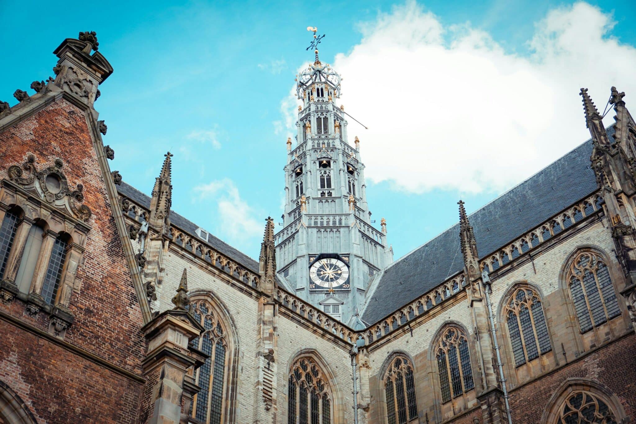 Stunning view of a gothic-style church tower under a bright blue sky.