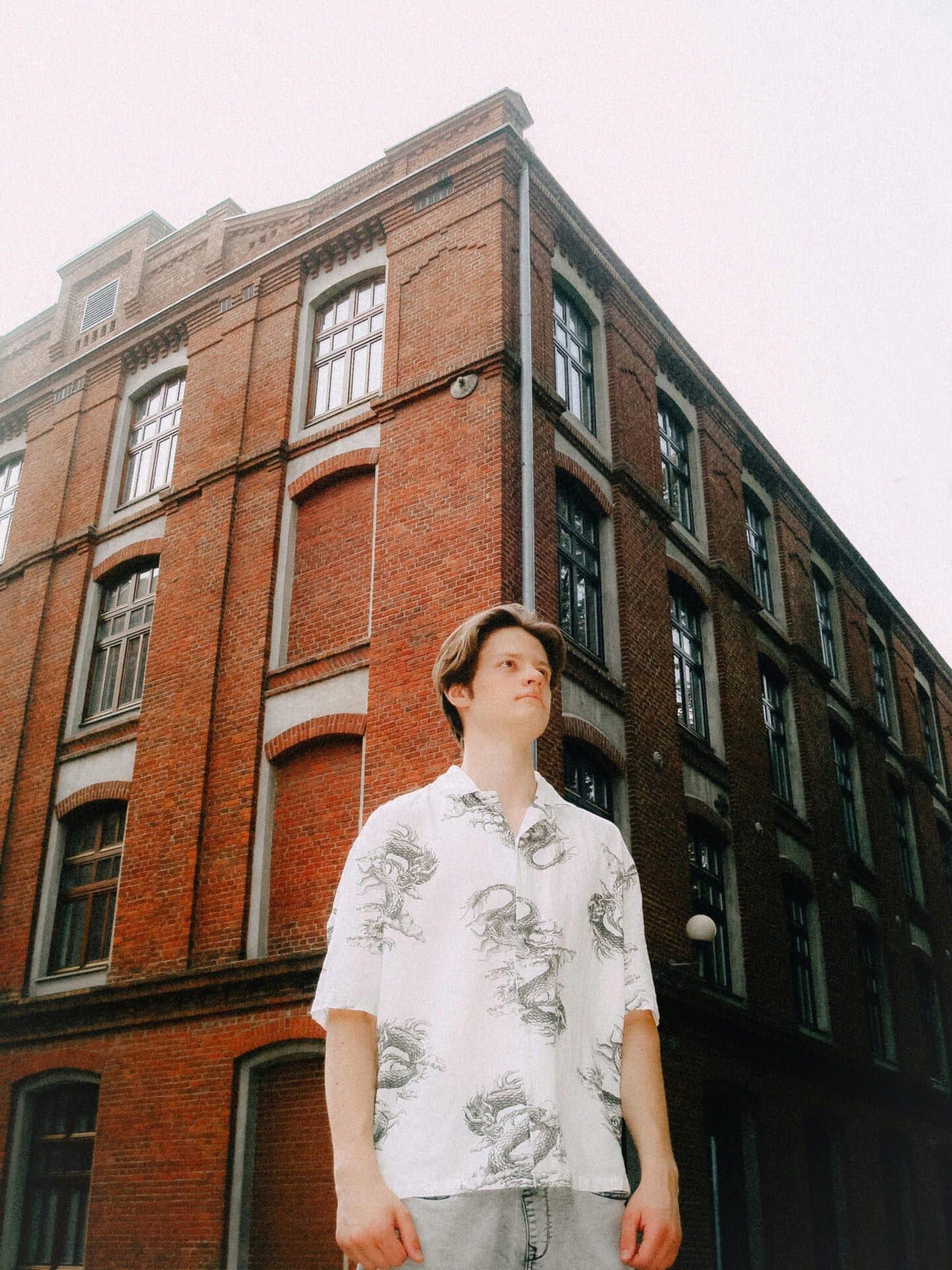 Man in Front of a Red-Brick Building in Lodz